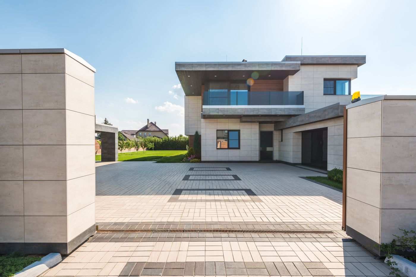 Gated contemporary home with stone facade and paver courtyard
